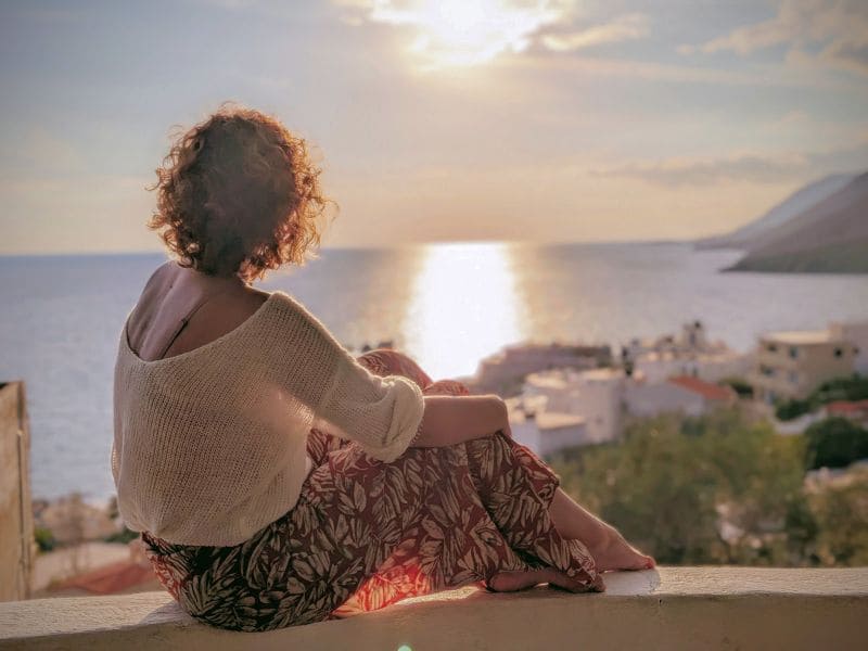 Person sitting quietly overlooking the sea at sunset in southern Crete