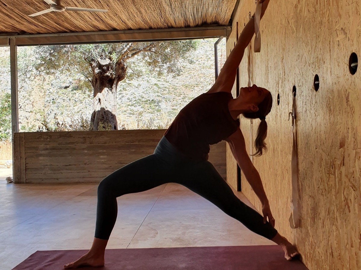 Iyengar yoga practice in a quiet studio in Crete with wall support and natural light